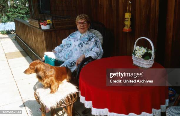 Johanna König, deutsche Schauspielerin und ehemalige Werbefigur, entspannt auf der Terrasse zu Hause in Berlin mit ihrem Dackel, Deutschland 1988.