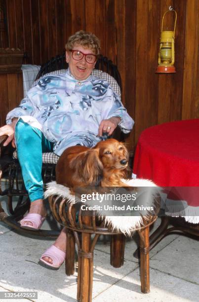 Johanna König, deutsche Schauspielerin und ehemalige Werbefigur, entspannt auf der Terrasse zu Hause in Berlin mit ihrem Dackel, Deutschland 1988.