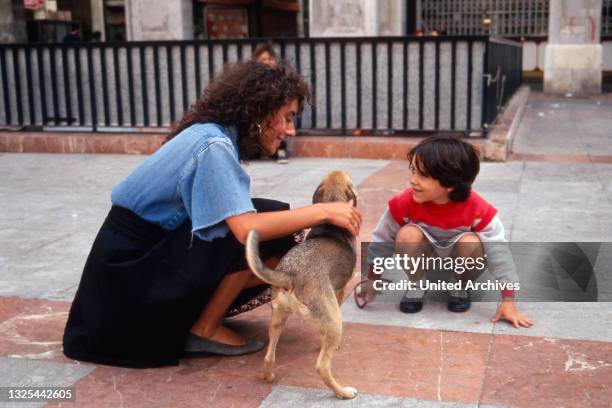 Maria Ketikidou trifft in Palma auf Mallorca ein Kind mit seinem Hund, Spanien 1988.