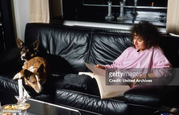 Maria Ketikidou, deutsche Schauspielerin, lernt ihren Text mit den Hunden auf dem Sofa zu Hause in Hamburg, Deutschland 1990.