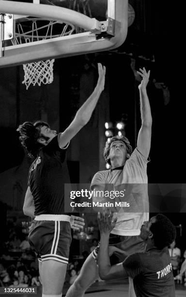 Player of the Phoenix Suns Paul Westphal shoots over former NBA player Jerry Lucas and NBA player of the Denver Nuggets David Thompson during the 3...