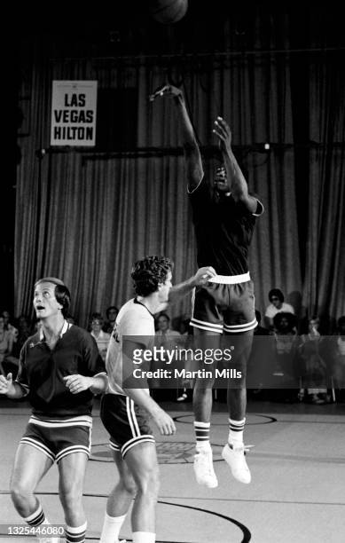 Player of the Denver Nuggets David Thompson shoots over NBA player of the Phoenix Suns Paul Westphal as American singer, composer, actor, writer,...