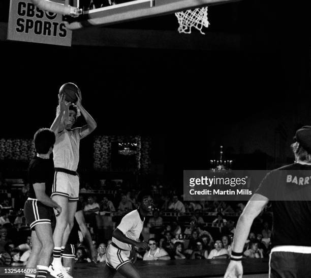 Player of the New Orleans Jazz "Pistol" Pete Maravich shoots over American actor Kent McCord as American actor LeVar Burton and NBA player of the...