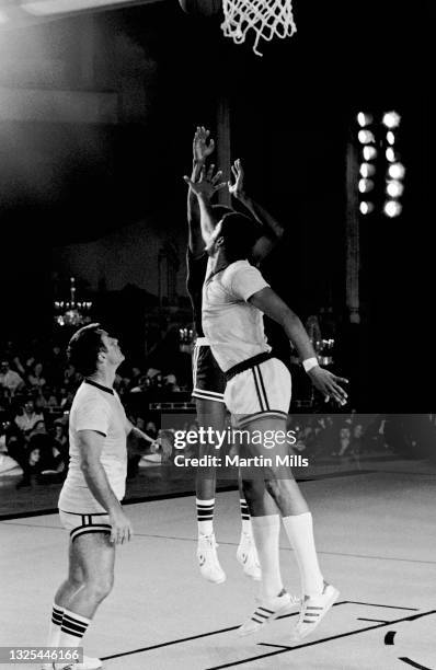 Player of the Philadelphia 76ers Julius Erving shoots over NBA player of the Portland Trail Blazers Maurice Lucas and American film and television...