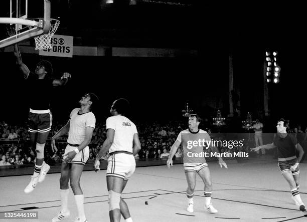 Player of the Philadelphia 76ers Julius Erving goes for the lay-up as NBA player of the Portland Trail Blazers Maurice Lucas , former NBA player Sam...