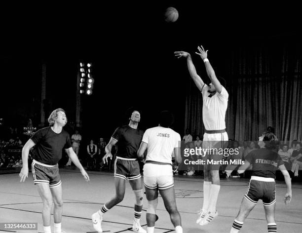 Player of the Portland Trail Blazers Maurice Lucas shoots as former NBA player Kevin Loughery, NBA player of the Philadelphia 76ers Julius Erving,...