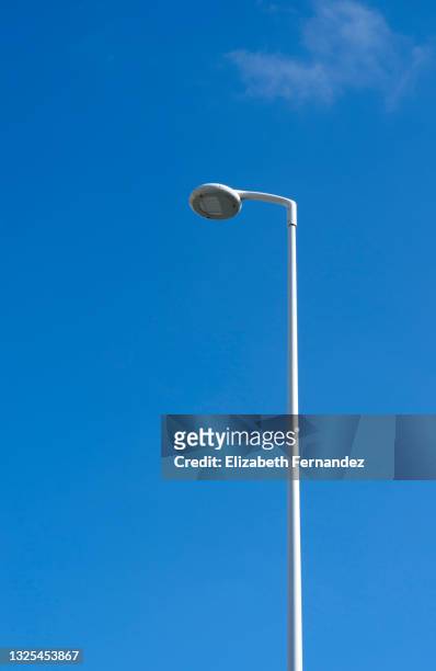 low angle view of street light against clear blue sky - poste fotografías e imágenes de stock