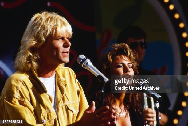 Matthias Reim, deutscher Rock-, Pop- und Schlagersänger, bei einem Auftritt mit Freundin Mago, Deutschland um 1993.