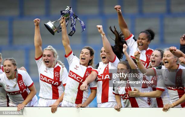 Emily Rudge of England lifts the Womens International trophy in celebration with teammates following victory in the Rugby League International match...