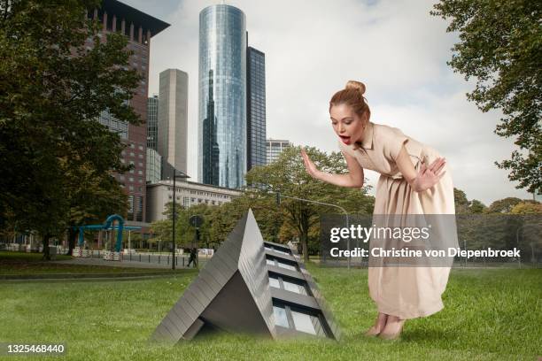 woman found a stunning plant on green ground - surrealism stock pictures, royalty-free photos & images