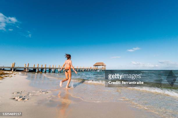 niña corriendo al agua en cancún - cancun fotografías e imágenes de stock