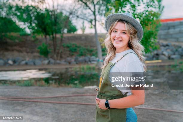 portrait of a happy young female caucasian farmer girl outdoors at a local small business farm-to-table supplier in colorado - economy rural in poland stockfoto's en -beelden