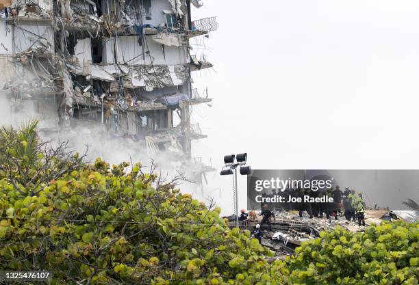 Members of the South Florida Urban Search and Rescue team look for possible survivors in the partially collapsed 12-story Champlain Towers South...