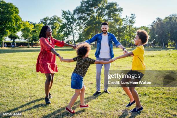 família feliz jogando anel em torno do rosado - brincadeira de roda - fotografias e filmes do acervo