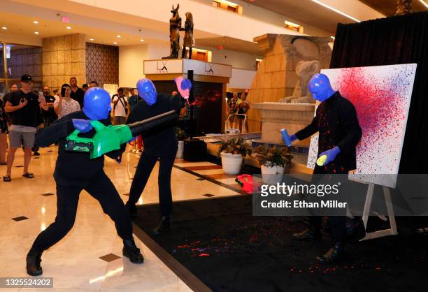 Members of Blue Man Group use a leaf blower to perform a paint routine on a canvas to reveal an exclusive work of art symbolizing "Blue is Back"...