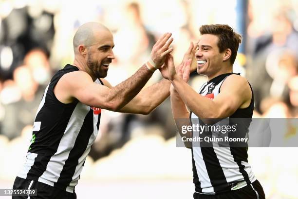 Josh Thomas of the Magpies is congratulated by Steele Sidebottom of the Magpies after scoring a goal during the round 15 AFL match between the...