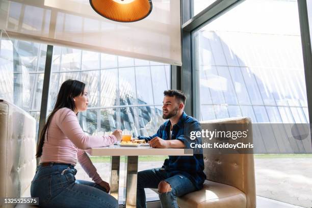 two friends enjoying the day and eating in restaurant - cosy pub stock pictures, royalty-free photos & images