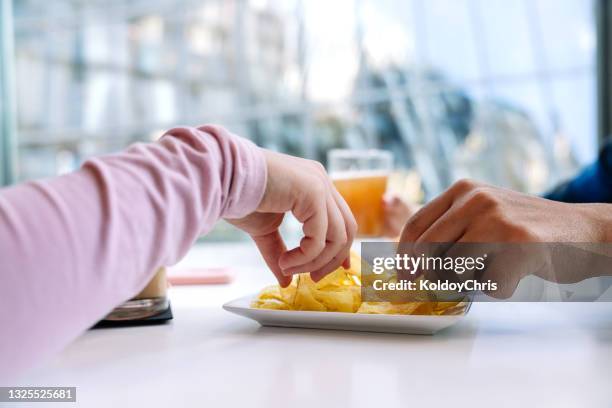 close-up of the hands of some friends sharing potato chips in restaurant - fast food french fries stock pictures, royalty-free photos & images