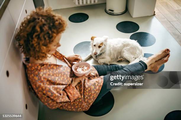 beautiful redhead eating breakfast on the kitchen floor - eating cereal stock pictures, royalty-free photos & images