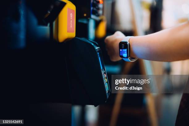 close up of a woman's hand paying with her smartwatch on a vending machine, scan and pay a bill on a card machine making a quick and easy contactless payment. nfc technology, tap and go concept - wearable computer bildbanksfoton och bilder