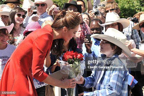 Catherine, Duchess of Cambridge receives a bouquet of roses from a young boy as she departs the ENMAX Conservatory, Calgary Zoo for Challenger Rotary...