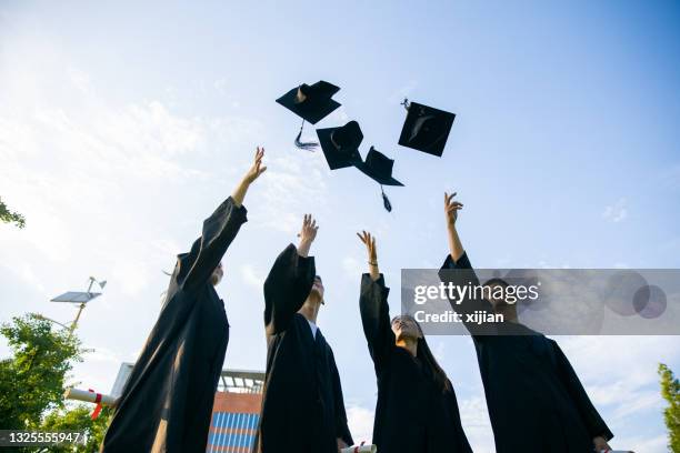 college students celebrating their graduation - graduation hat imagens e fotografias de stock