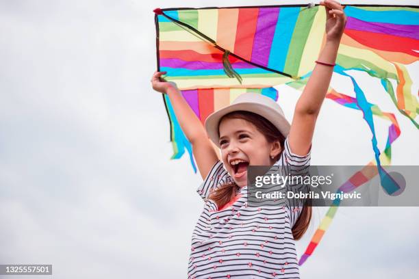 lächelndes junges mädchen mit drachen - kite toy stock-fotos und bilder