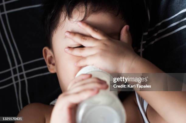 headshot portrait of a southeast asian baby boy while lying on the bed - baby close up bed stock pictures, royalty-free photos & images