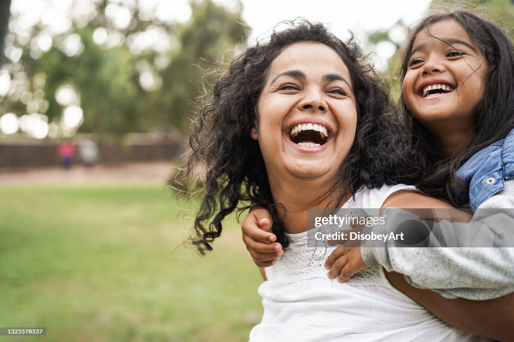 Happy indian mother having fun with her daughter outdoor - Family and love concept - Focus on mum face