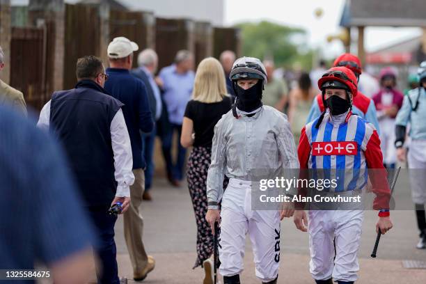 General view as Richard Kingscote and Martin Dwyer make their way through the large crowd to the parade ring at Windsor Racecourse on June 26, 2021...