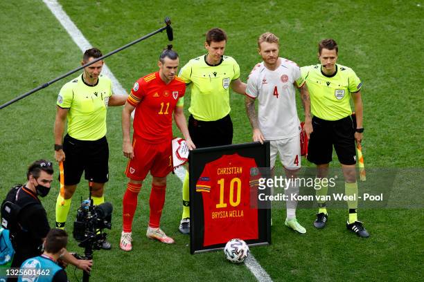 Gareth Bale of Wales and Simon Kjaer of Denmark pose for a photo with a Christian Eriksen of Denmark shirt with Officials, Match Referee, Daniel...