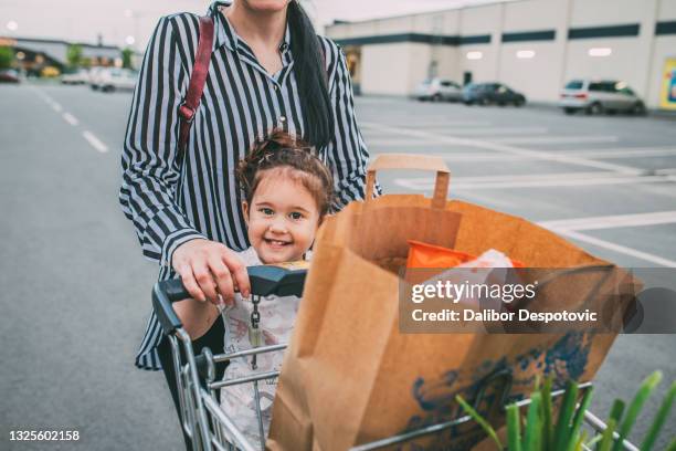 mom with her child in front of the supermarket - paper bag stock pictures, royalty-free photos & images