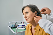 Hearing check-up. Senior citizen woman receives tympanometry with tympanometer probe at hearing clinic. Close-up