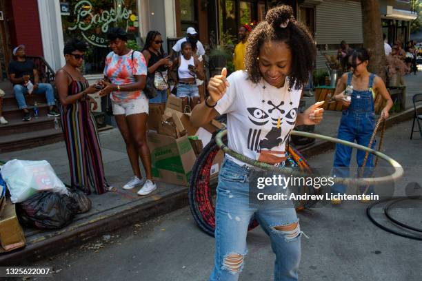 People practice with hula hoops at a block party on June 20, 2021 in the Bedford-Stuyvesant neighborhood of Brooklyn, New York. With vaccination...