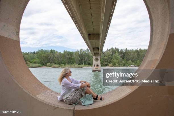 woman relaxes in architectural sphere under bridge - under the skirt stock pictures, royalty-free photos & images