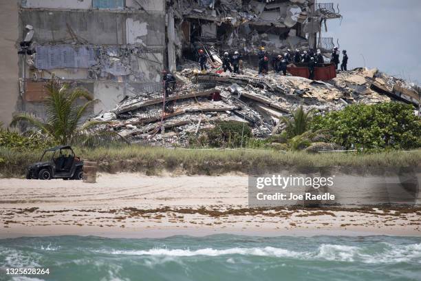 Members of the South Florida Urban Search and Rescue team look for possible survivors in the partially collapsed 12-story Champlain Towers South...