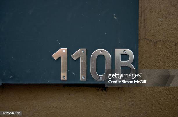 stainless steel street address number 110b on a building exterior - house number stock pictures, royalty-free photos & images
