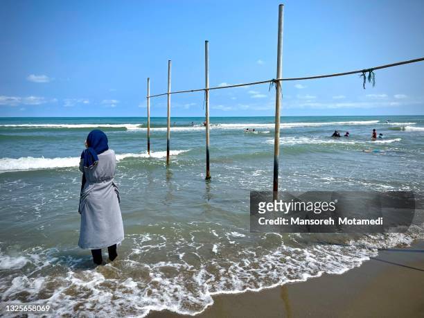 alone muslim woman next to the sea - muslim woman beach - fotografias e filmes do acervo