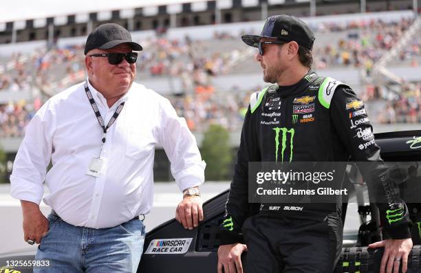 Kurt Busch, driver of the Monster Energy Chevrolet, and team owner Chip Ganassi talk on the grid prior to the NASCAR Cup Series Pocono Organics CBD...