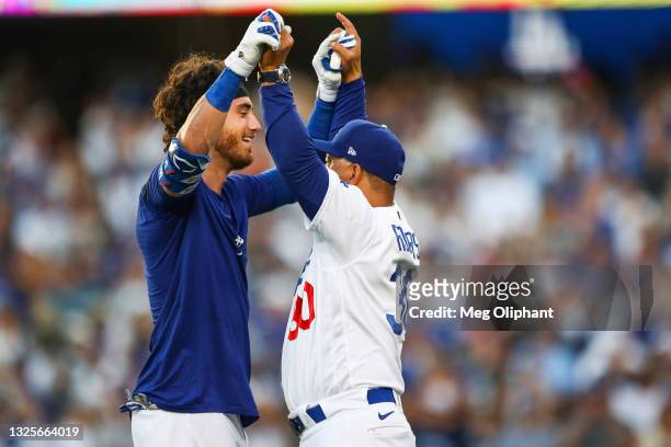 Cody Bellinger of the Los Angeles Dodgers celebrates his walk off home run against the Chicago Cubs with manager Dave Roberts in the ninth inning at...