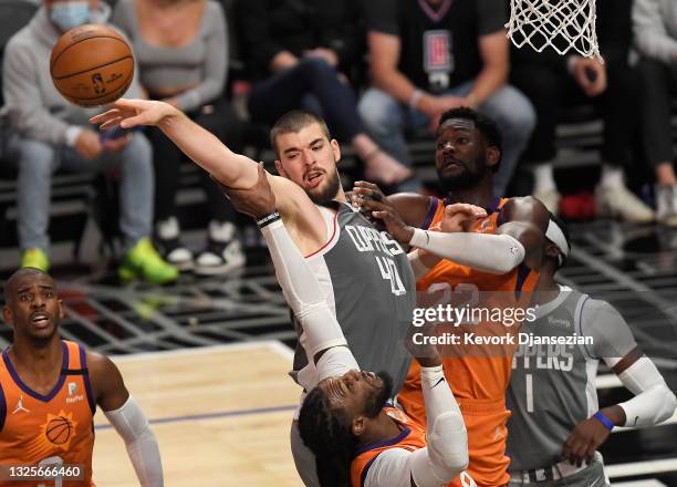Ivica Zubac of the LA Clippers is defended by Jae Crowder and Deandre Ayton of the Phoenix Suns during the second half in game four of the Western...
