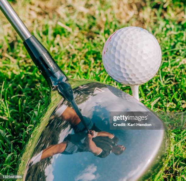 a man's stance is reflected in a golf club - golfschläger stock-fotos und bilder