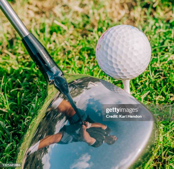 a man's stance is reflected in a golf club - golf swing close up stock pictures, royalty-free photos & images