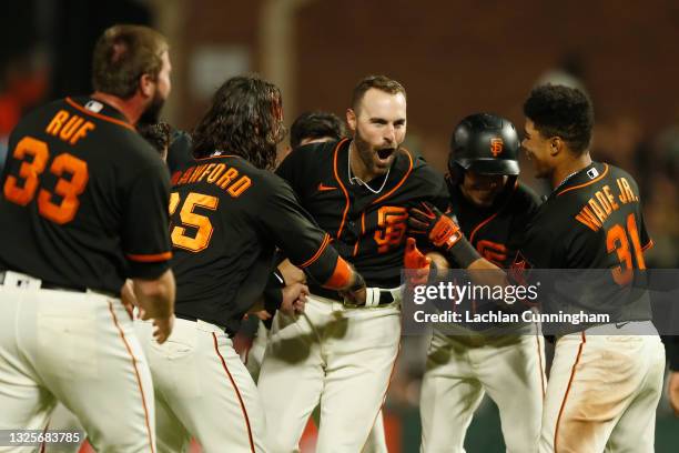 Curt Casali of the San Francisco Giants celebrates with teammates after hitting a walk-off RBI double in the bottom of the tenth inning against the...