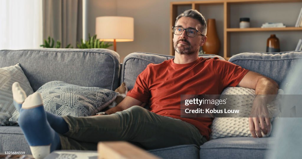 Schuss eines reifen Mannes entspannen auf dem Sofa zu Hause
