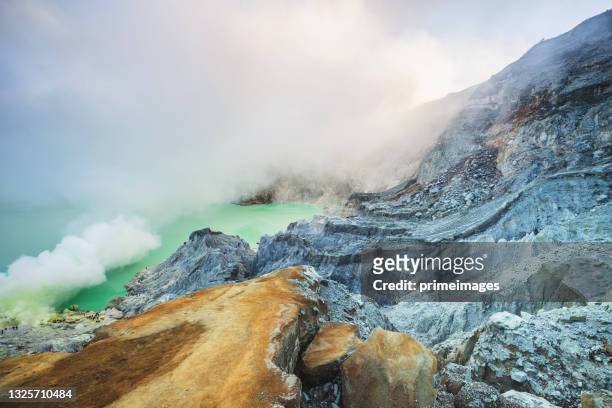vista del lago ácido del volcán humeante kawah ijen en indonesia. paisaje de montaña - bromo crater fotografías e imágenes de stock