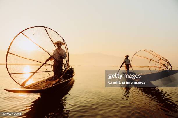 misty morning sunrise scenics view of intha fisherman in inle lake at sunrise ,myanmar - myanmar culture stockfoto's en -beelden