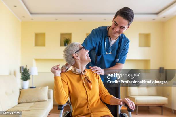 healthcare worker is in home visit to an older woman with physical disabilities. - nursing assistant stock pictures, royalty-free photos & images