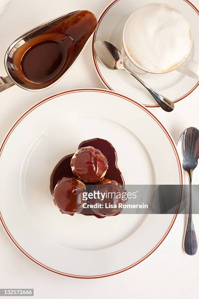 profiteroles with chocolate sauce and coffee - profiterole stock-fotos und bilder