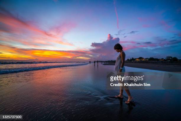 tourist at the beach side sunset at canggu indonesia with purple sky - romantic sky stock pictures, royalty-free photos & images